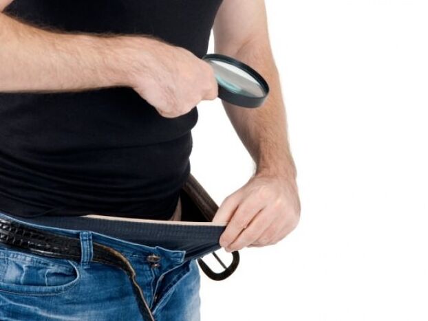 un home mira para abaixo os pantalóns e quere agrandar o pene